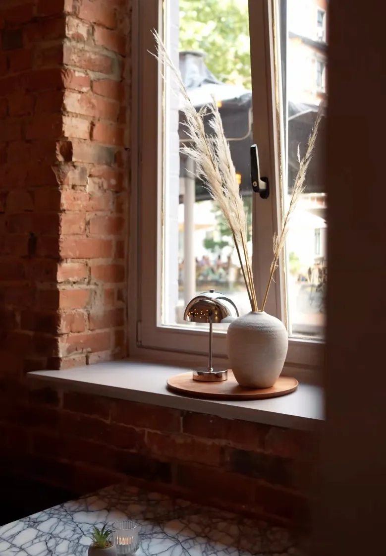 Fensterplatz mit Vase und warmer Atmosphäre